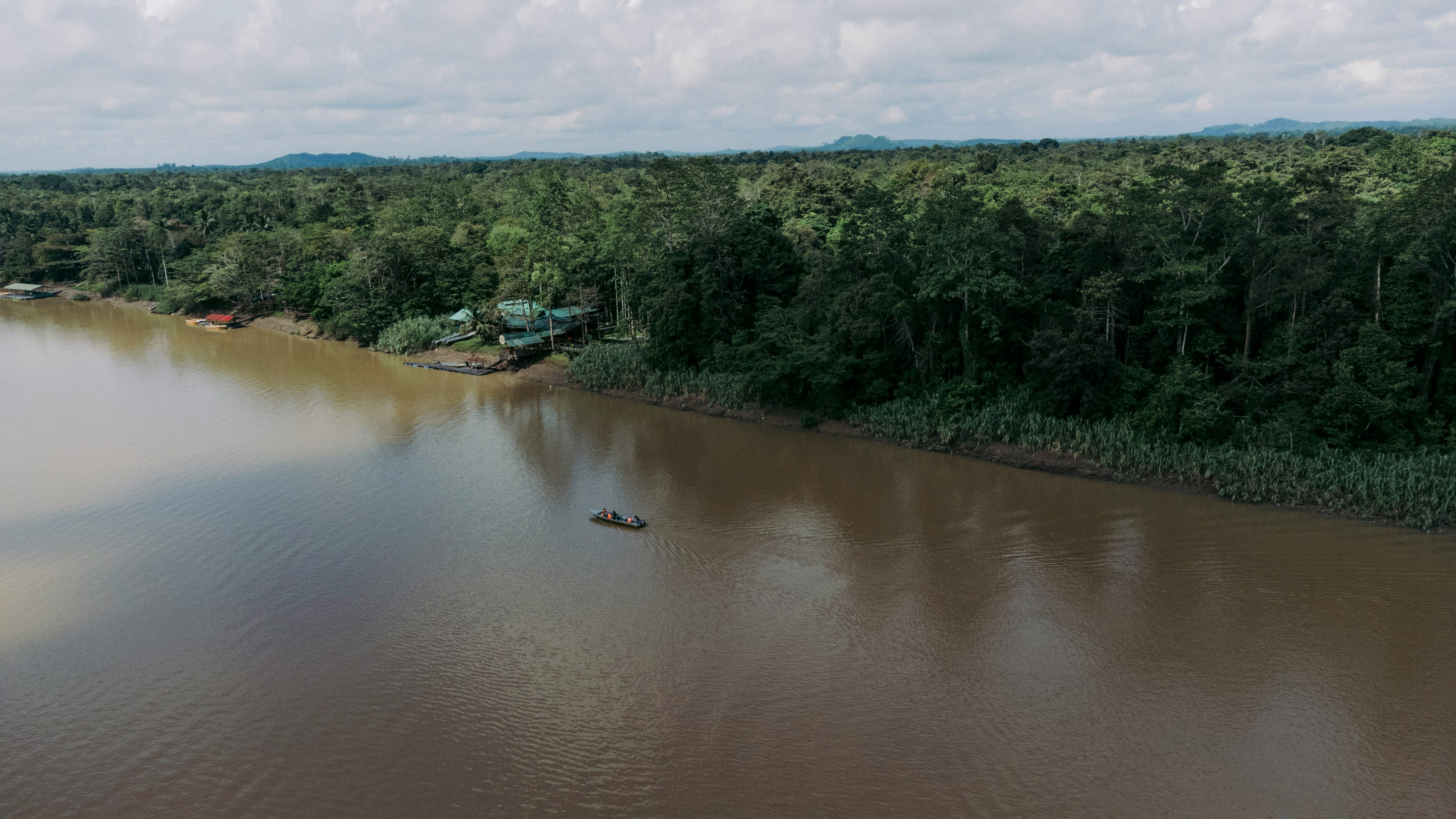 Panoramic landscape of the Amazonian River, the coast, the river with a boat navigating and the forest