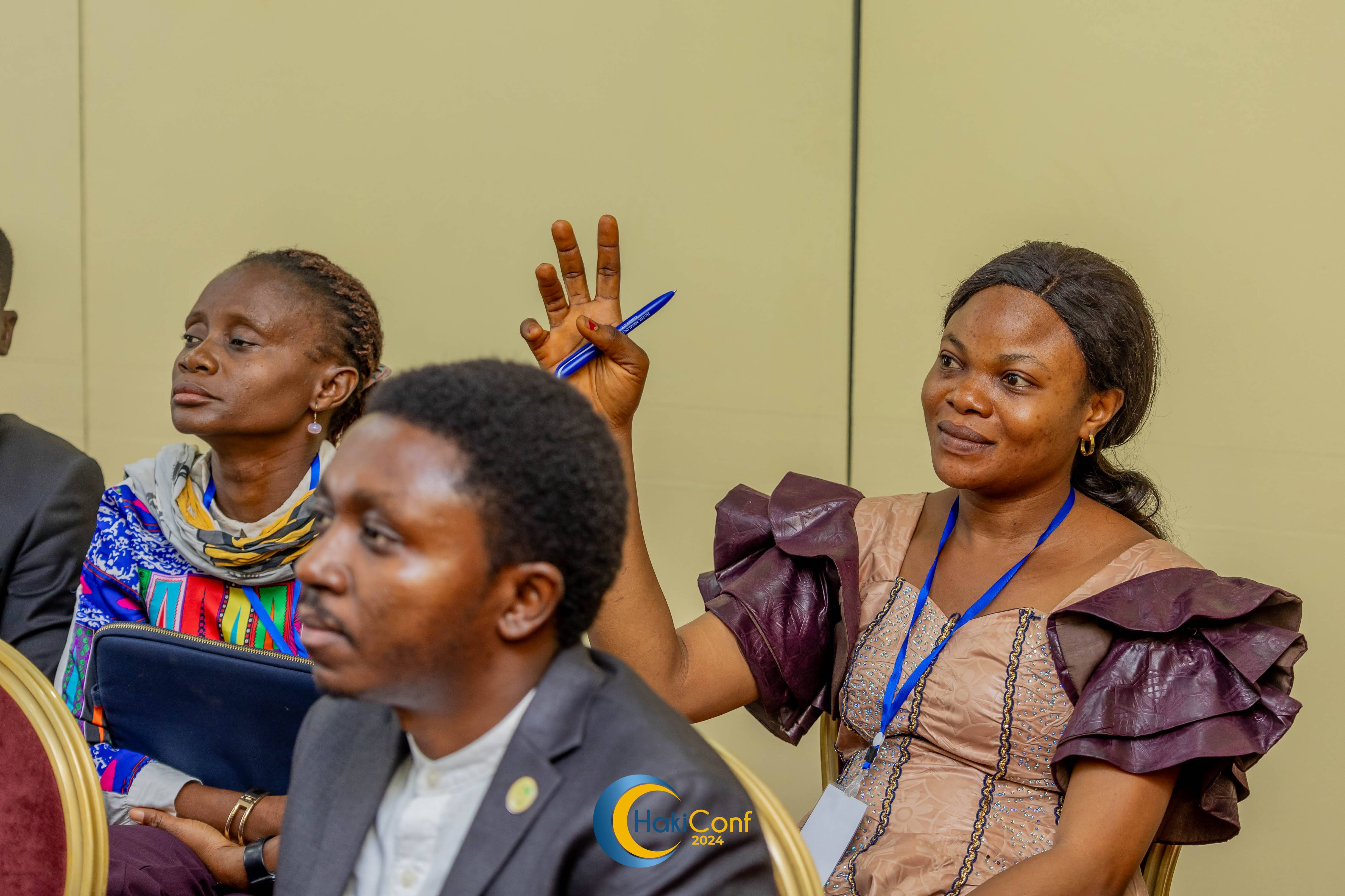 Image of three participants listening to discussions during HakiConf 2024 in Kinshasa, DRC.