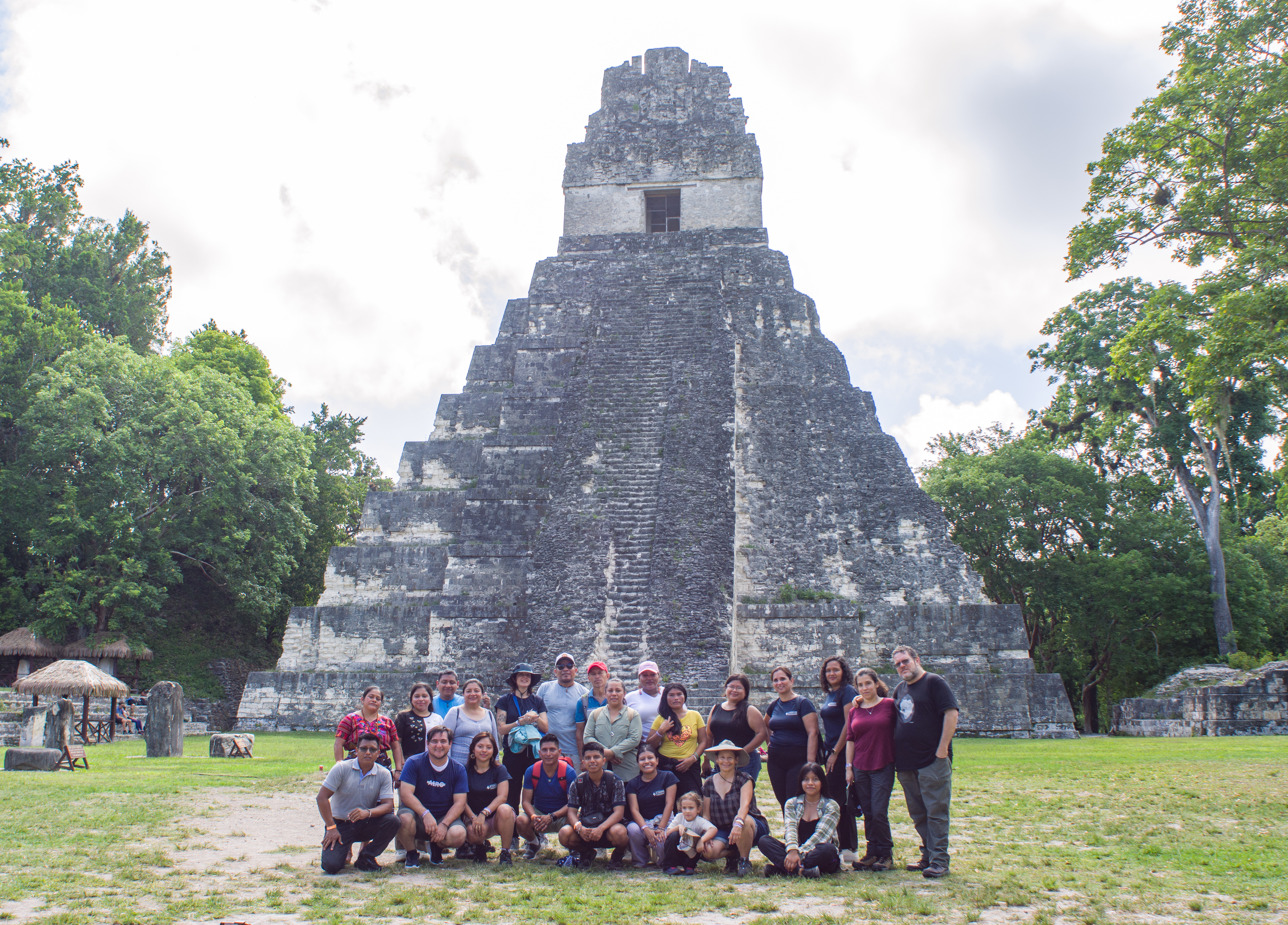 Un grupo de personas posando para una foto debate de una piramide arqueologica.