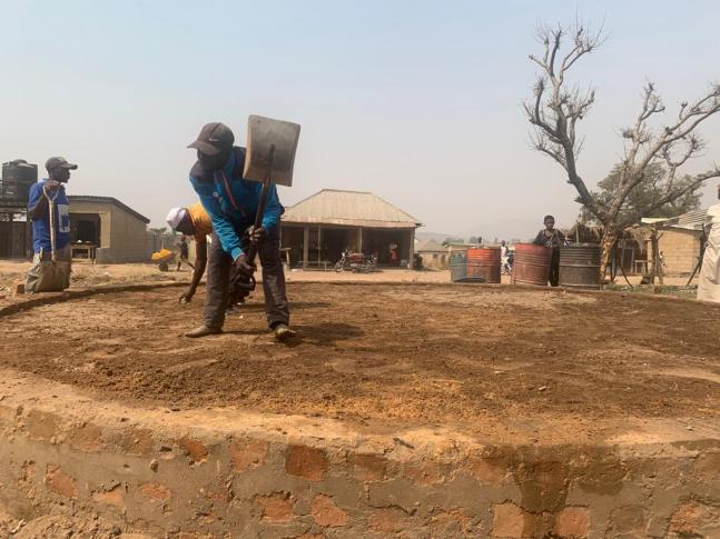 Community members flatten the foundation for a new Hello Hub in Dakwa. Photo courtesy of Hello World and CITAD.