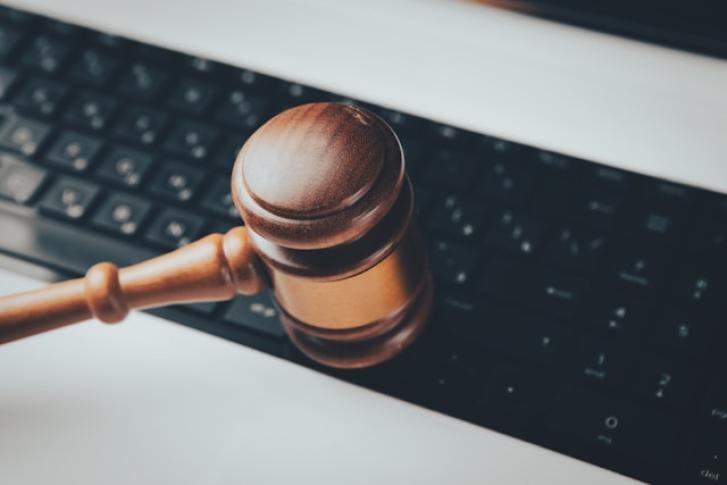 Cover image: Photo of a wooden gavel sitting on top of a computer keyboard by Sasun Bughdaryan.