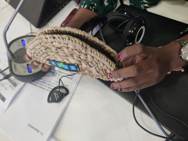Durante la sesión del 2 de diciembre, una participante muestra el dispositivo Raspberry Zero que usan en su comunidad para grabar y enviar audio a la estación de radio local. Está envuelto en un estuche de junco tradicional para que resulte más familiar a la gente de la comunidad.